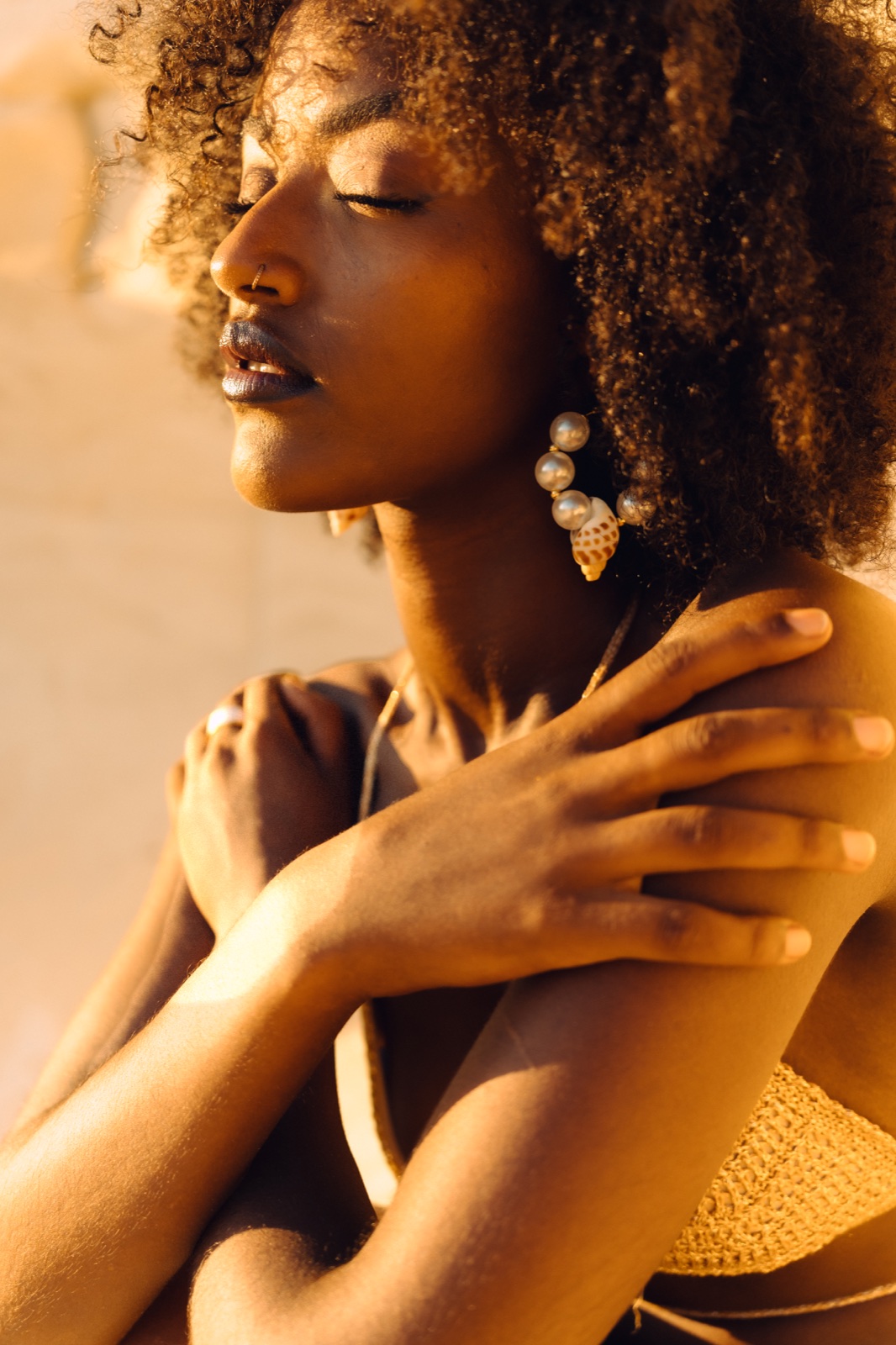 Model wearing LUME shell and pearl earrings